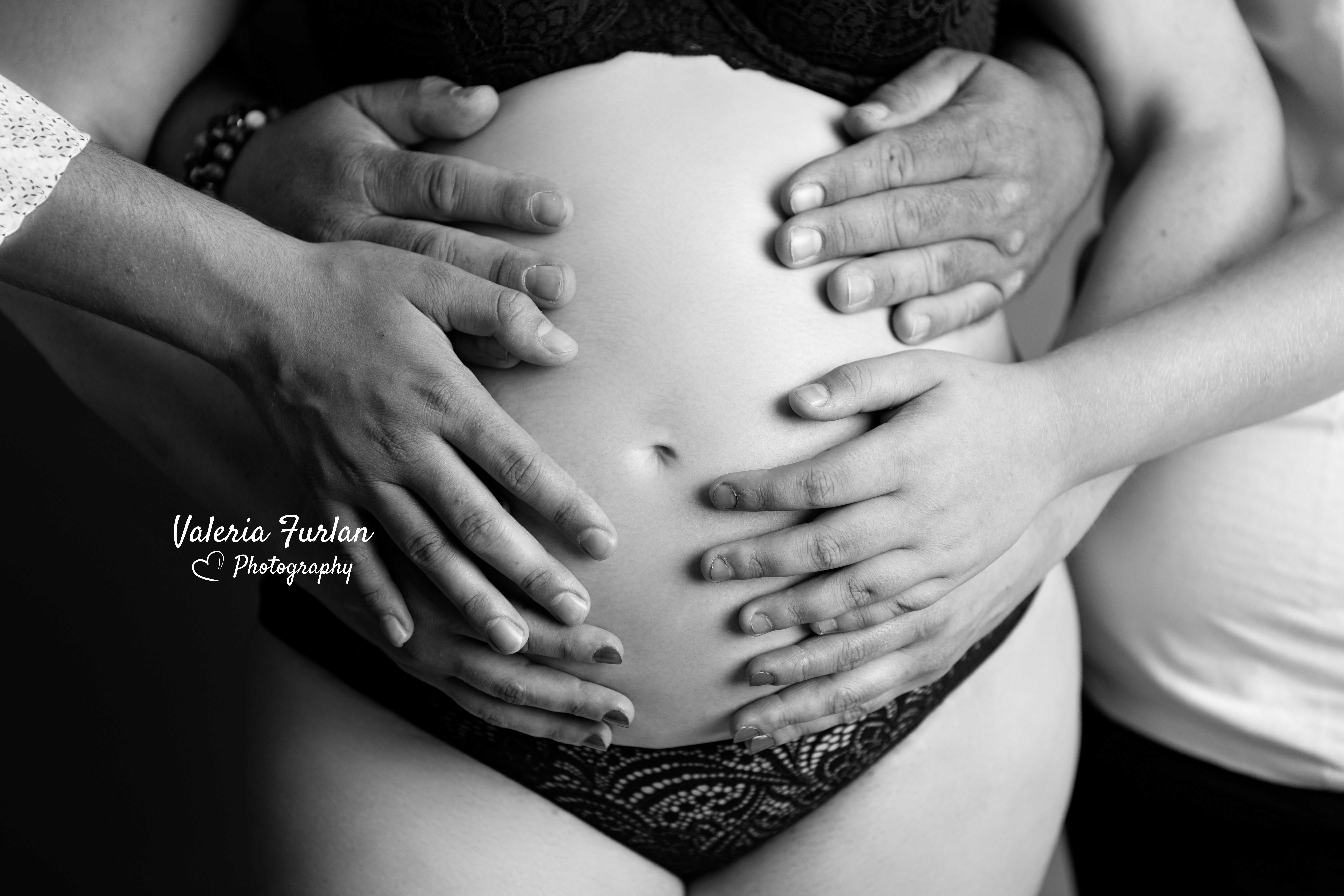 Photo de grossesse en noir et blanc mains sur le ventre
