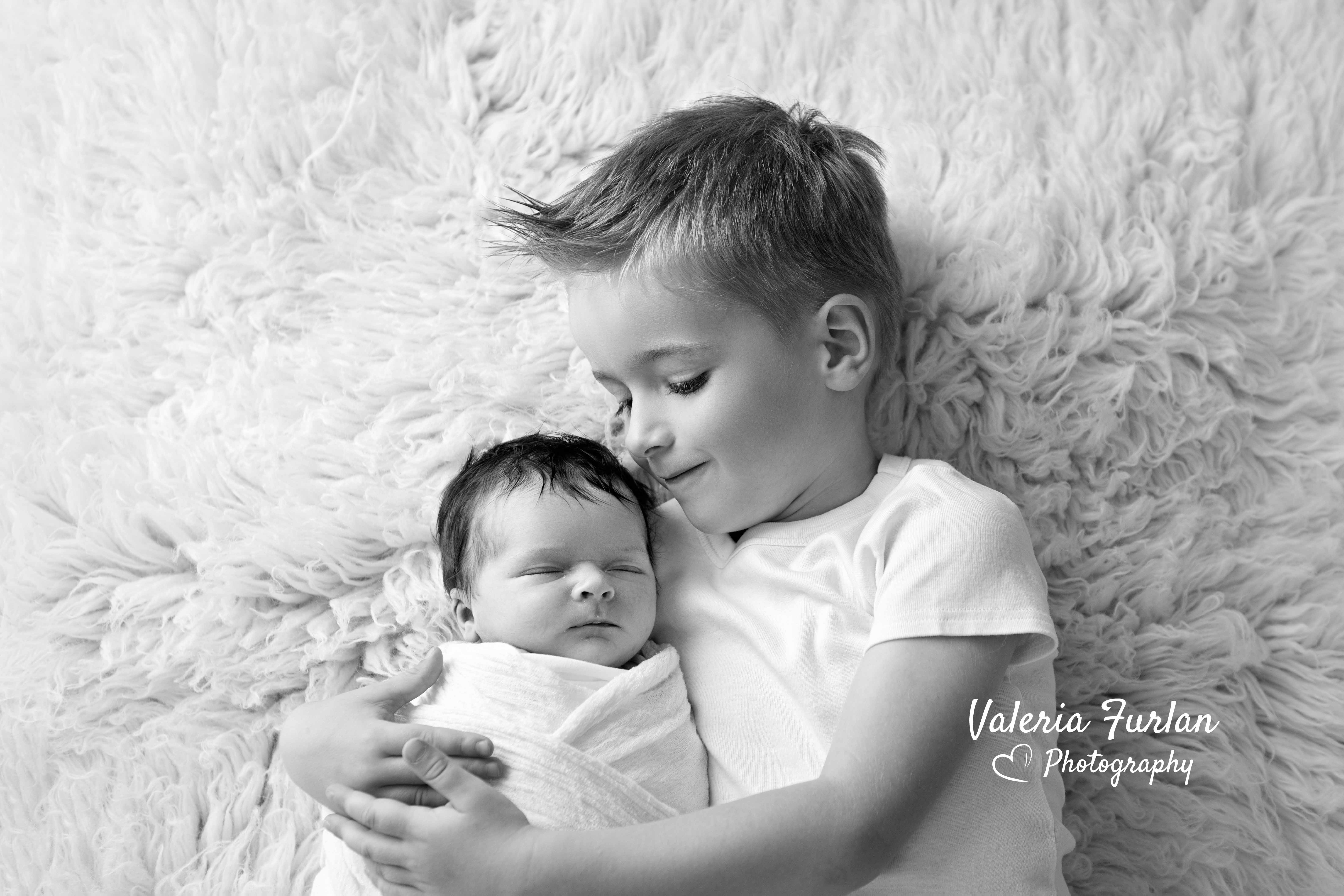 Séance photo de naissance newborn posing bébé avec grand frère